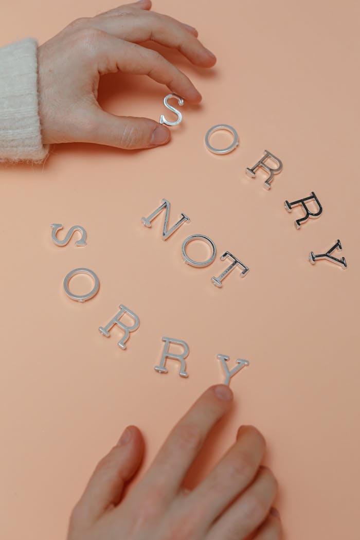 Hands arranging letters spelling 